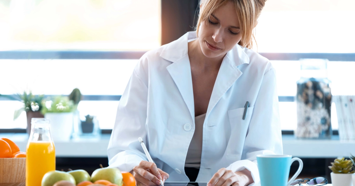 Dedicated health expert, with a colorful spread of healthy fruits and vegetables highlighting the focus on nutritional assessment for Micronutrient Testing in Akron, OH.