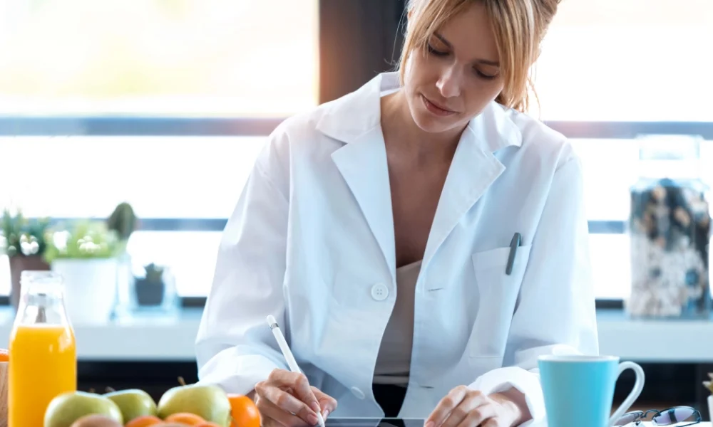 Dedicated health expert, with a colorful spread of healthy fruits and vegetables highlighting the focus on nutritional assessment for Micronutrient Testing in Akron, OH.